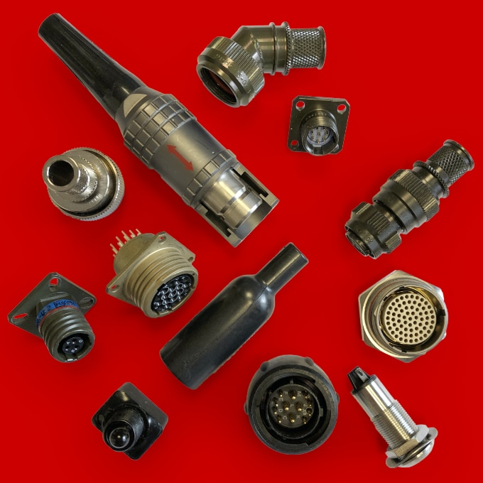 A selection of connectors, heatshrink boots and switches on a red background